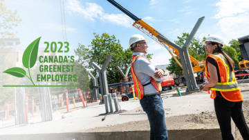 People in high-visibility vests on a construction site, logo featuring green leaf and text: 2023 Canada's Greenest Employers