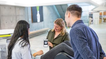 Dr. Shannon Kolind showing an MRI scan of a brain on her phone screen to students
